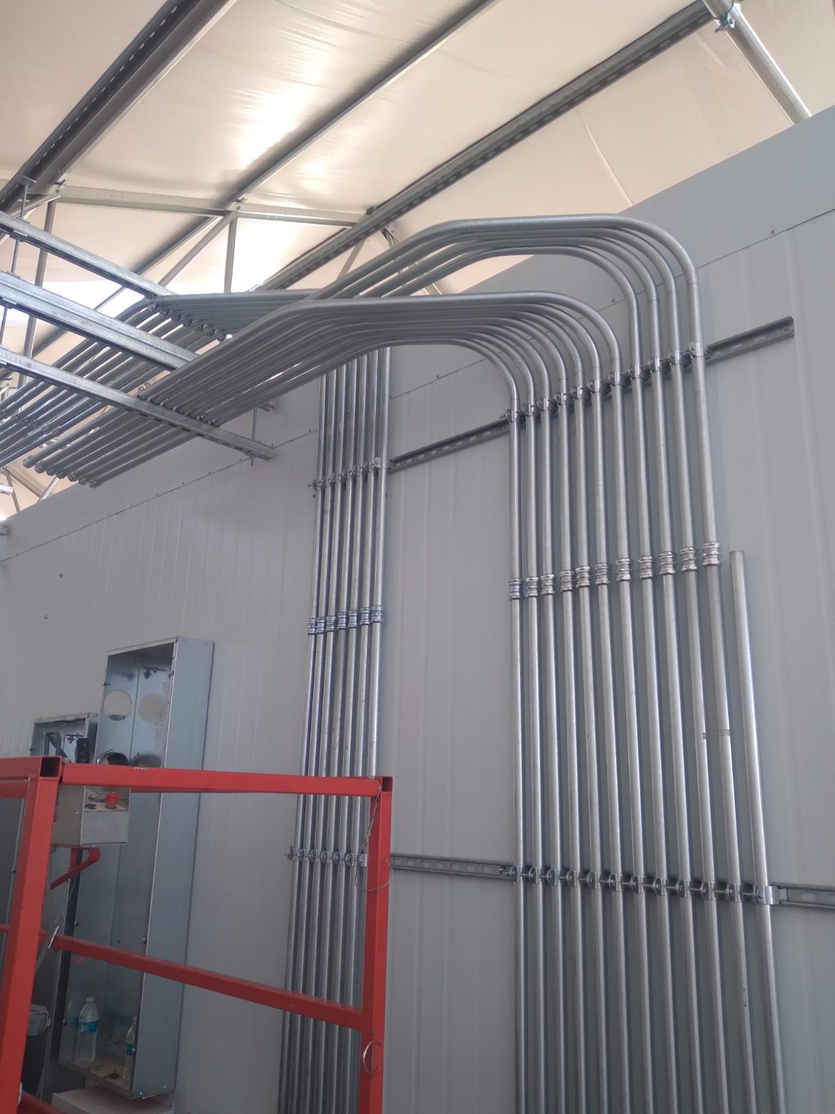 A bank of matched conduit 90s sweeping off a wall into gear on a commercial job